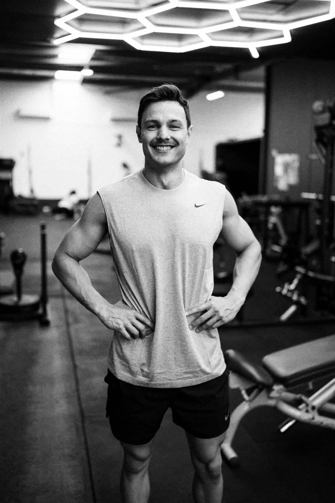 Gerard Majda smiling, hands on his hips, on the gym floor.